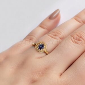 Yellow gold ring with oval alexandrite and milgrain detailing styled on hand.