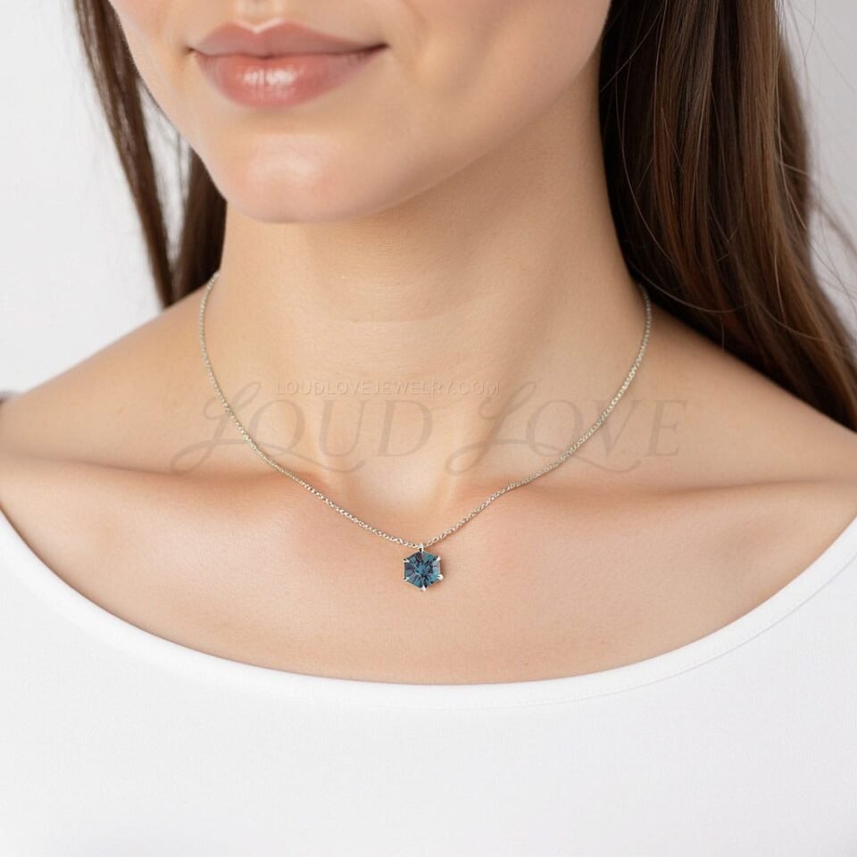 Luminous hex-cut alexandrite set in prongs, shown in a sleek white gold necklace.