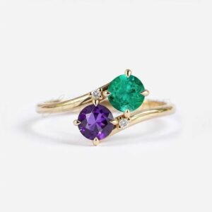 Round amethyst and lab emerald in a bypass setting with two white accent stones.