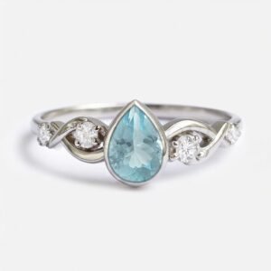 Pear cut natural aquamarine in bezel setting with marine-inspired white gold band.