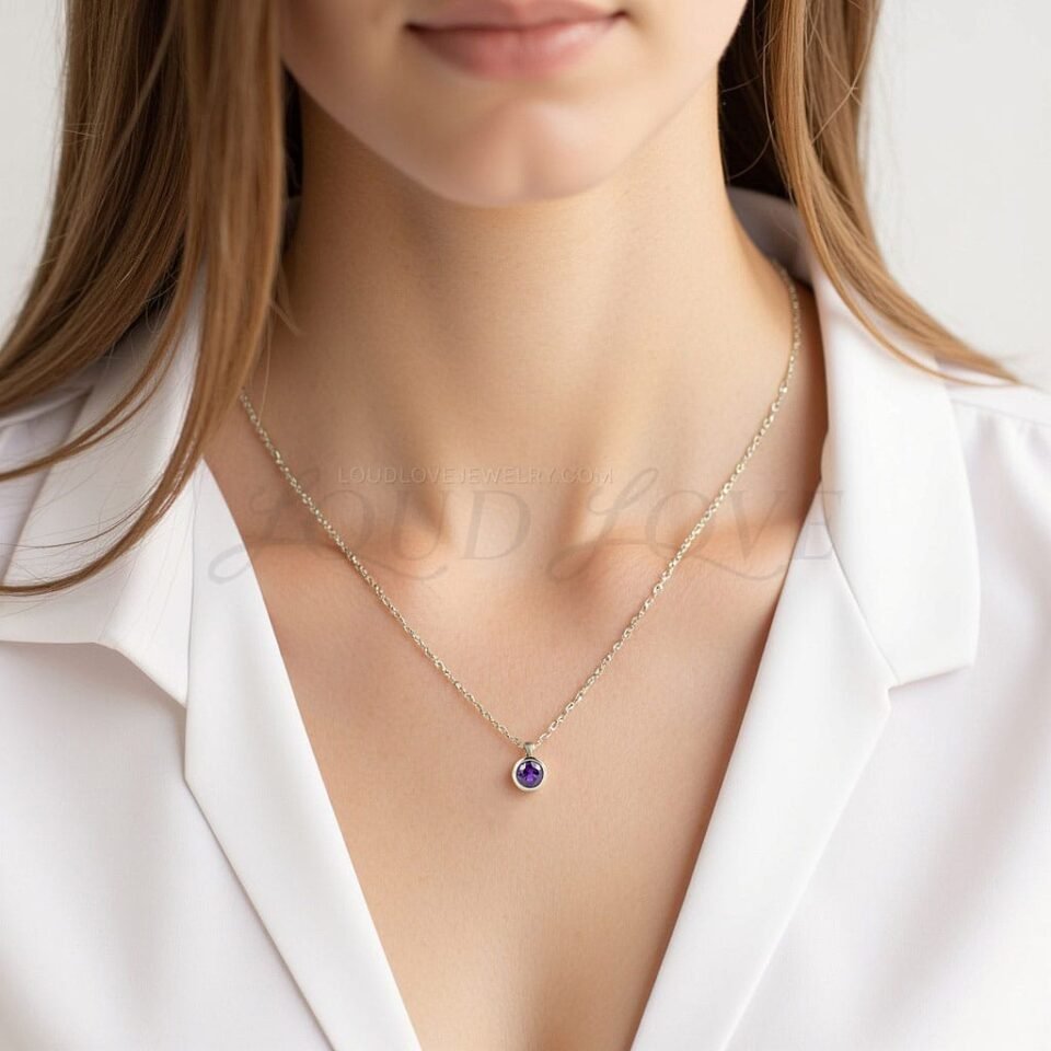 Bezel-set round amethyst necklace worn to mark February birthdays with elegant simplicity.