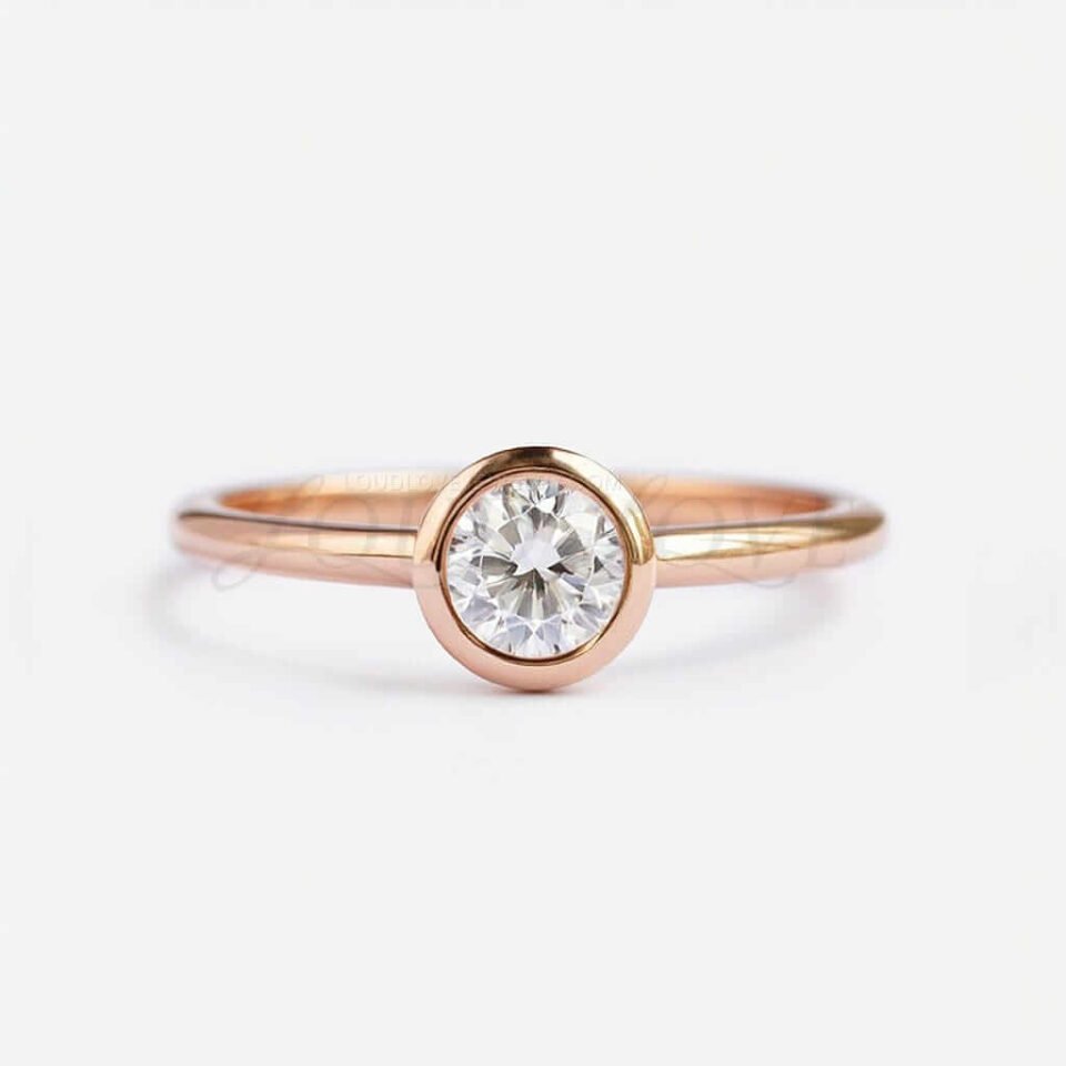 Classic bezel set round moissanite engagement ring with rose gold band.