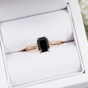 Glossy black onyx and white accents set in warm rose gold, arranged in a sophisticated ring box.
