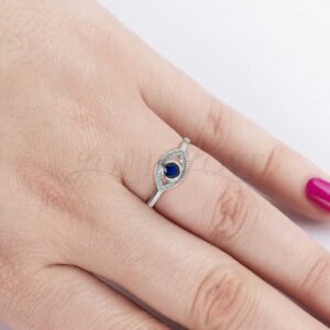 Evil eye design ring with lab sapphire styled on hand as a symbolic accessory.