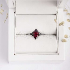 Enchanting ring with deep garnet and black stones arranged in a dramatic, witch-inspired design.