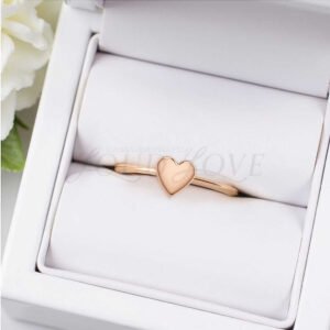Rose gold heart ring placed in an elegant display setting.