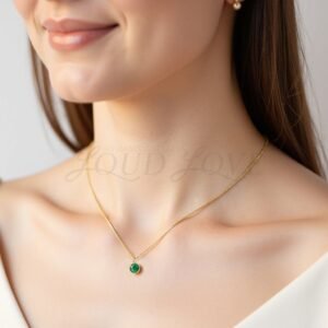 Minimalist necklace with bezel-set emerald, styled to honor May birthdays with natural elegance.