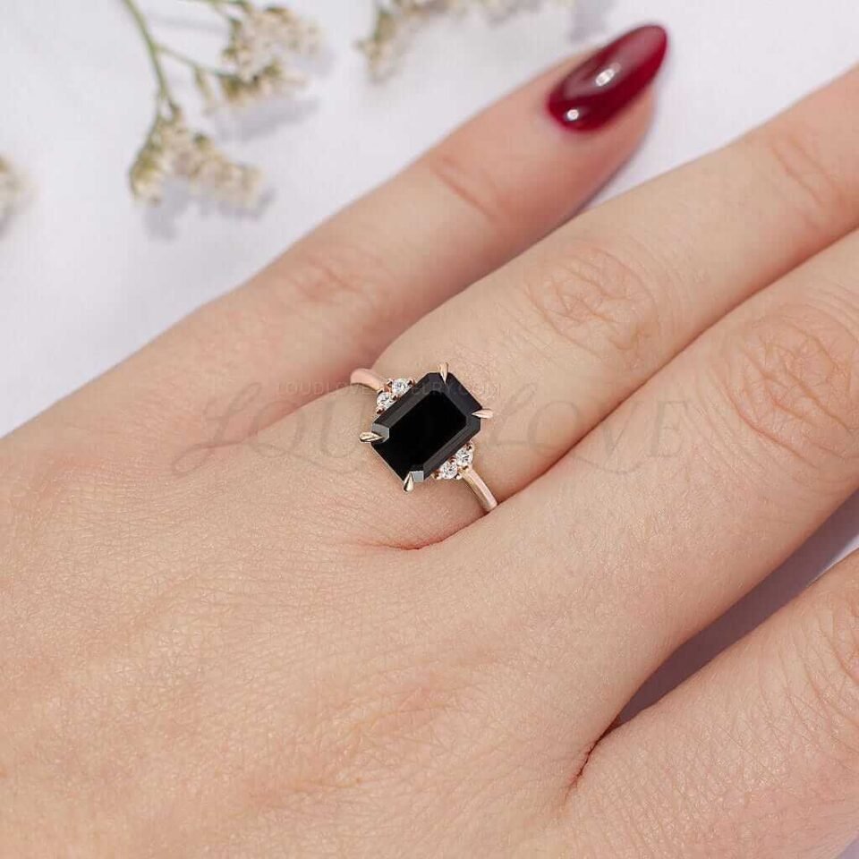 Striking rose gold ring with black onyx center and sparkling side stones.