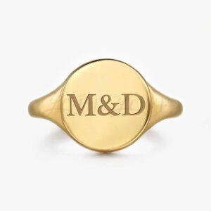 Gold ring with M&D engraving on a white background.