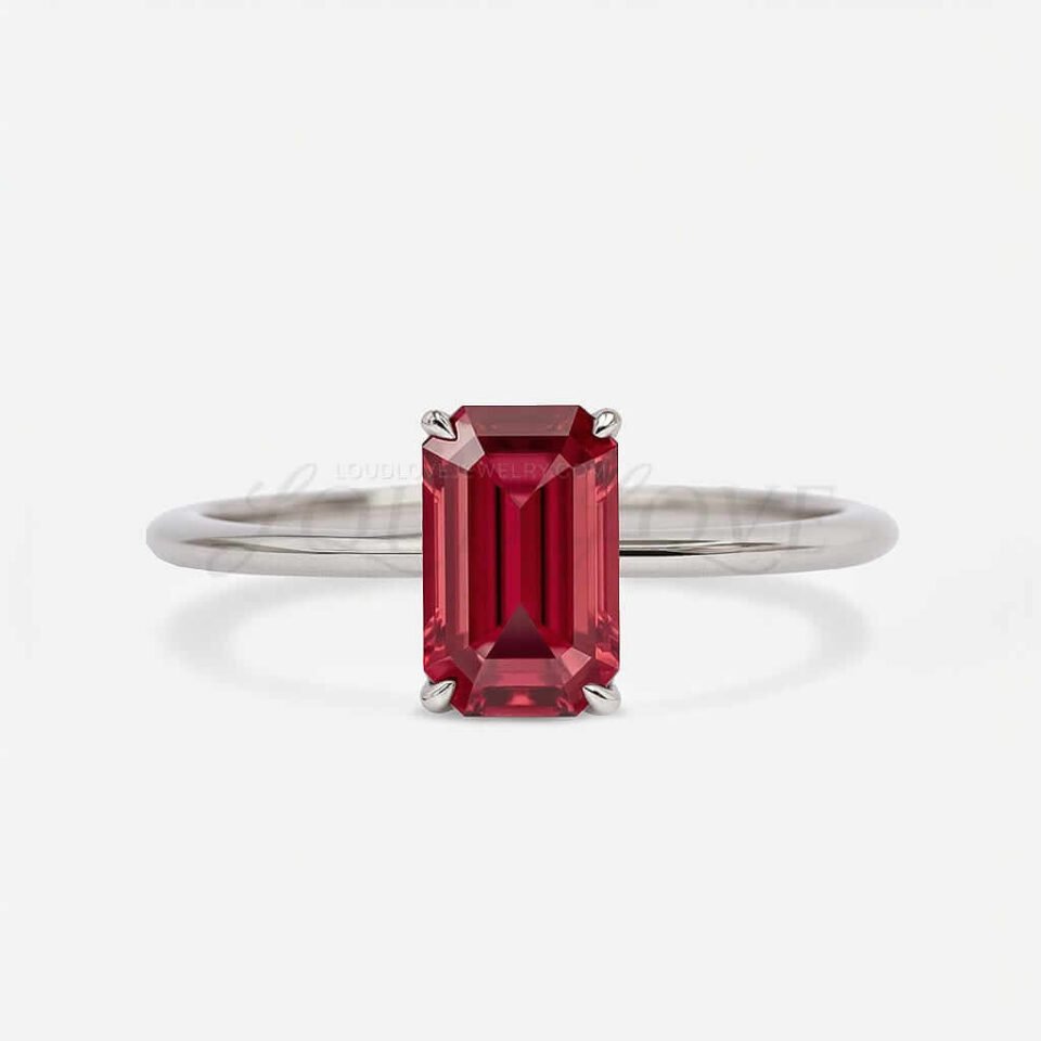 Emerald-cut garnet solitaire set with four claws on a smooth white gold band, minimal and timeless.