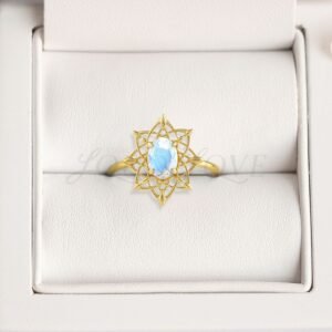 Oval moonstone ring with detailed gold dreamcatcher setting displayed in a cushioned holder.
