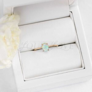 Classic promise ring featuring oval opal in claw setting, presented in an elegant jewelry box.