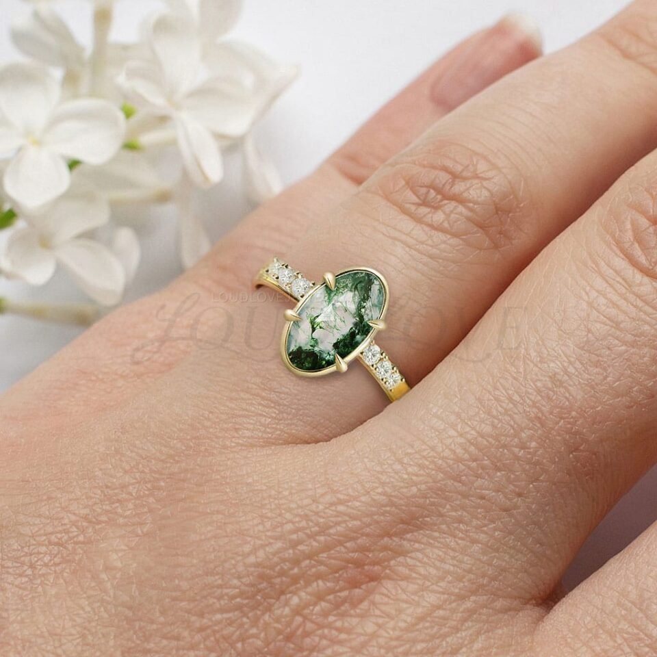 Earthy moss agate ring with gold rim and accent stones worn for a distinctive elegant look.