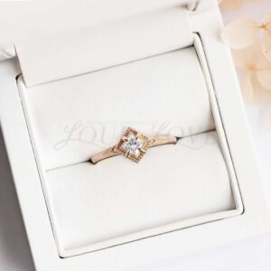 Princess moissanite ring with vintage details and bold gold rim in display.