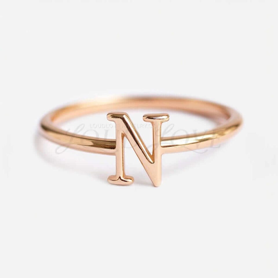 A gold ring featuring the initial "N" on a white background.