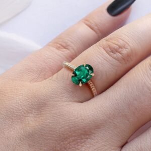 Emerald ring with moissanite accents styled as a unique modern engagement piece.
