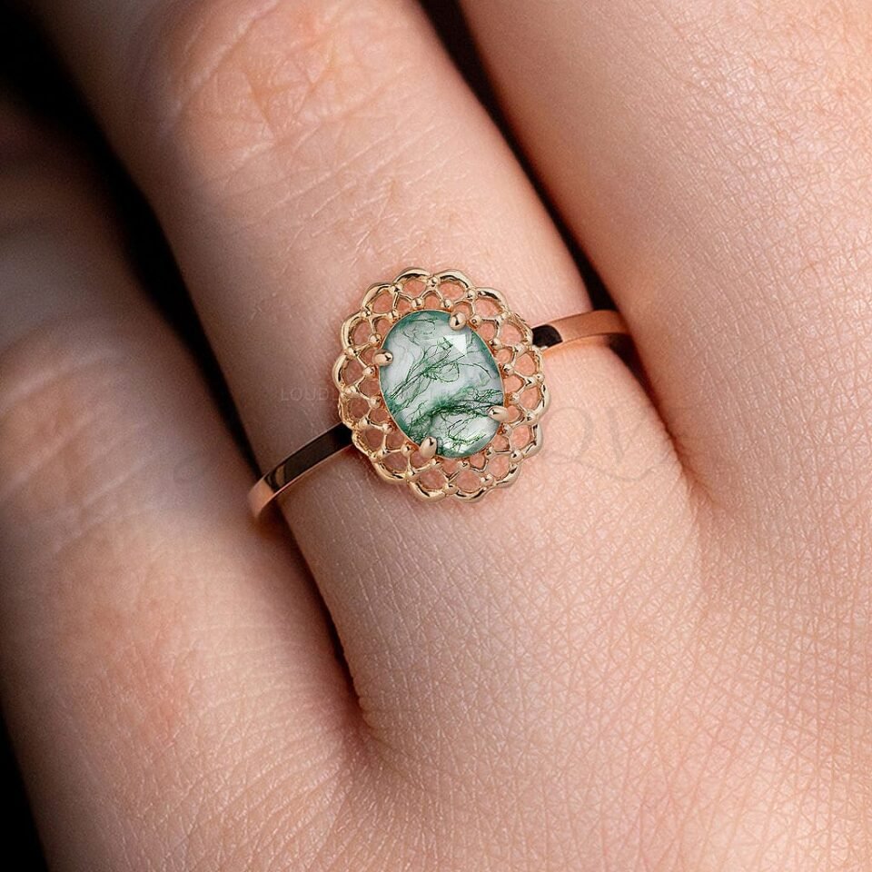 Delicate moss agate ring with lace detail, worn on ring finger.