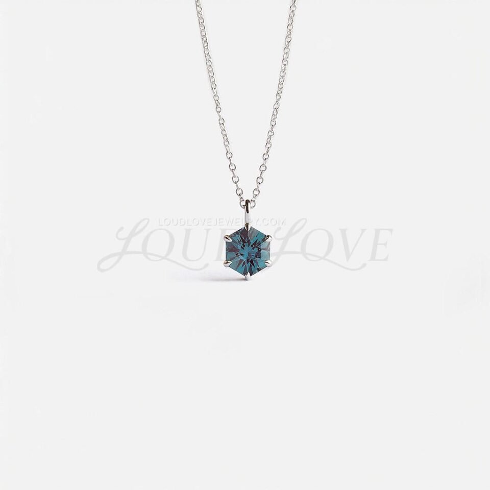 Hexagon-cut lab alexandrite in a white gold prong setting, displaying elegant color-shifting hues.