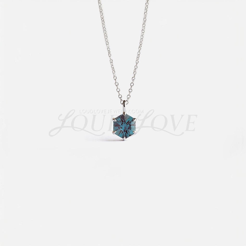 Hexagon-cut lab alexandrite in a white gold prong setting, displaying elegant color-shifting hues.