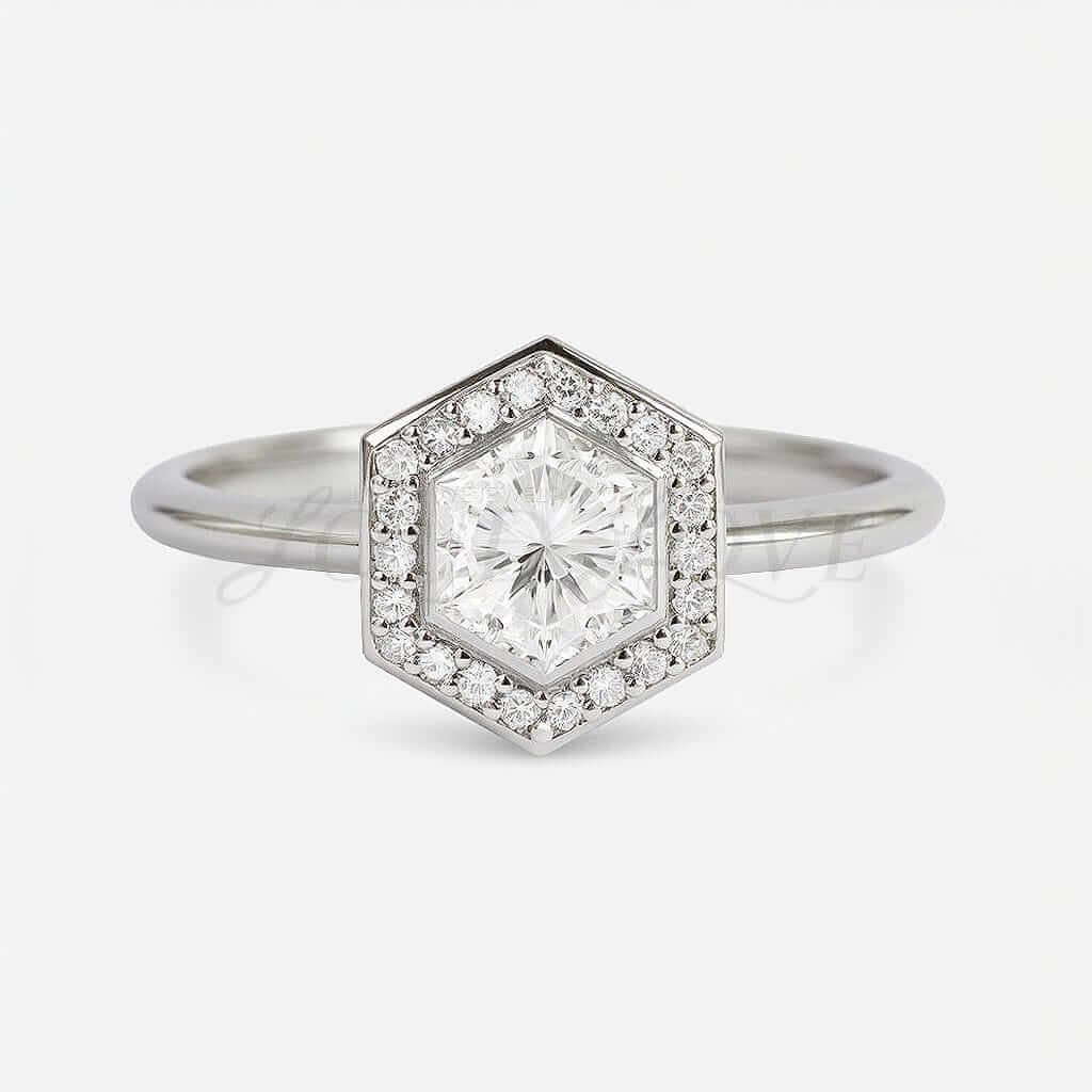 White gold engagement ring with bezel-set hexagon moissanite and channel halo.