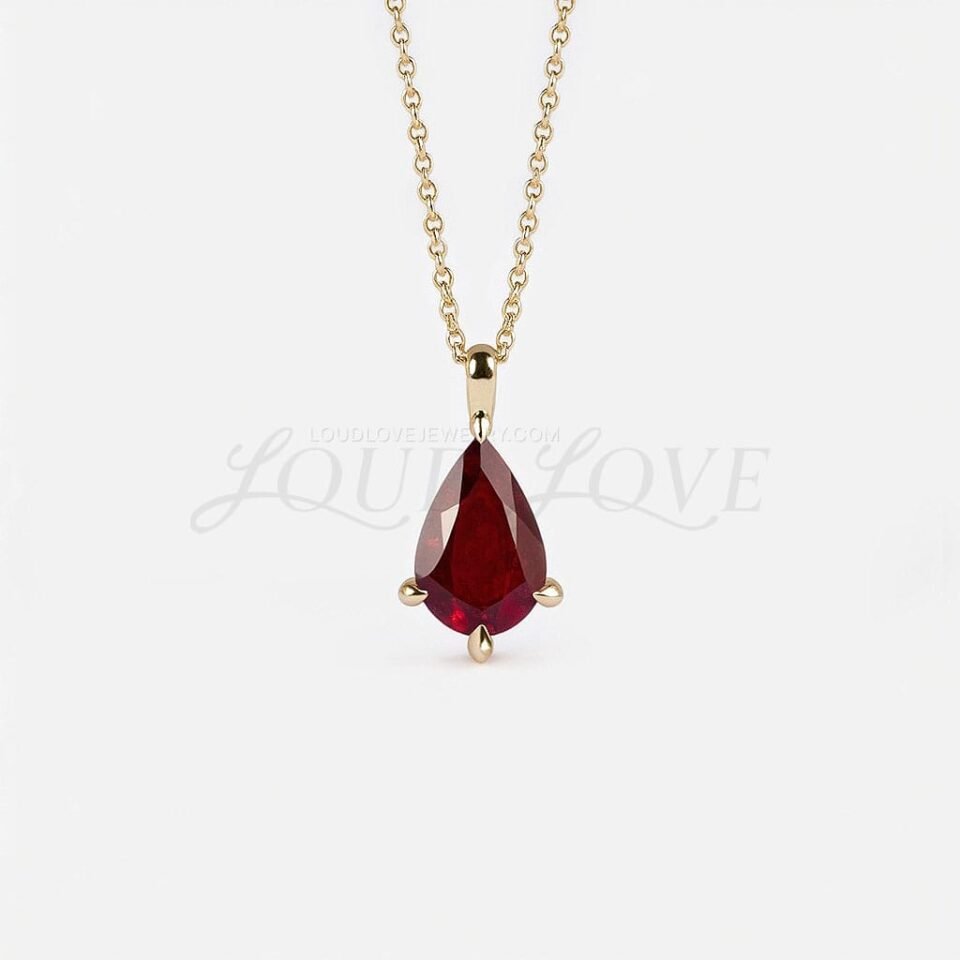 Pear-cut garnet solitaire pendant on a fine gold chain, representing the January birthstone.