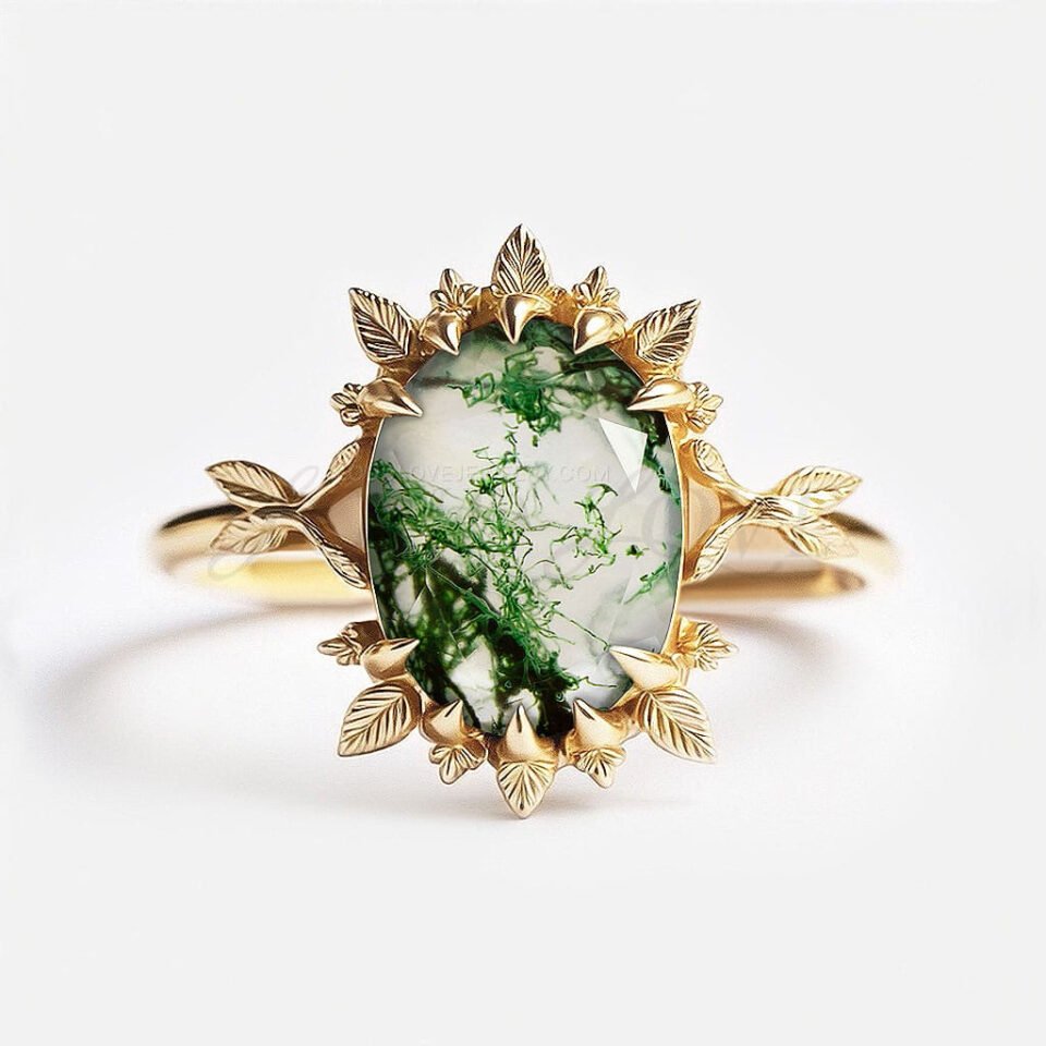 Large oval moss agate cocktail ring with a halo of gold leaf motifs around the stone.