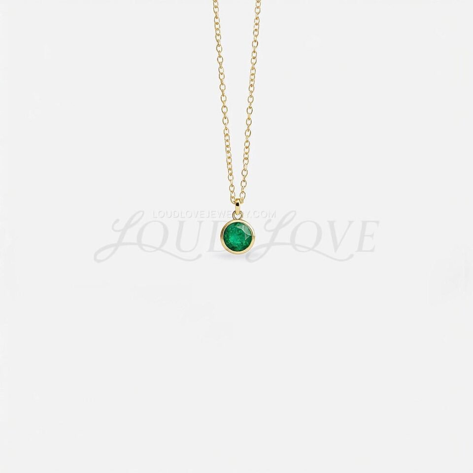 Round emerald in a bezel setting on a fine chain, capturing May's vibrant green birthstone.
