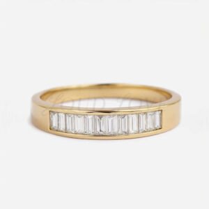 Yellow gold men's band featuring baguette diamonds.