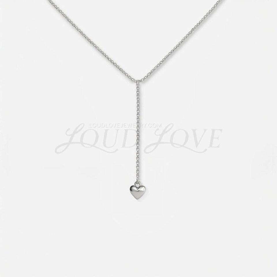 Delicate silver necklace with a slim drop ending in a tiny heart pendant, minimalist and sweet.