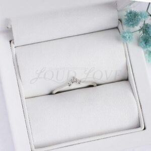 Gold wedding band with a three-stone setting in an elegant presentation case.