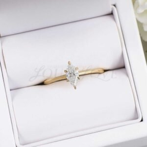 Yellow gold marquise cut moissanite engagement ring, shown with thin band.