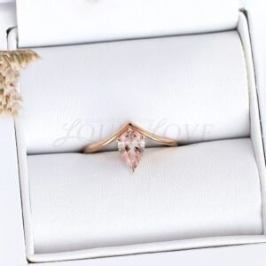 Sparkling pear-shaped pink morganite nestled in a rose gold V-band, displayed in a ring case.