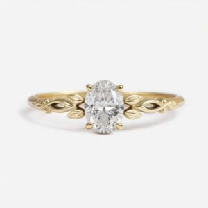 Oval moissanite in 4-prong setting with a nature-inspired yellow gold band featuring organic leaf details.