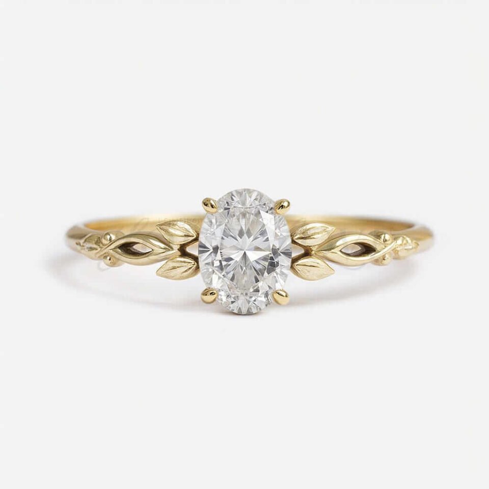 Oval moissanite in 4-prong setting with a nature-inspired yellow gold band featuring organic leaf details.