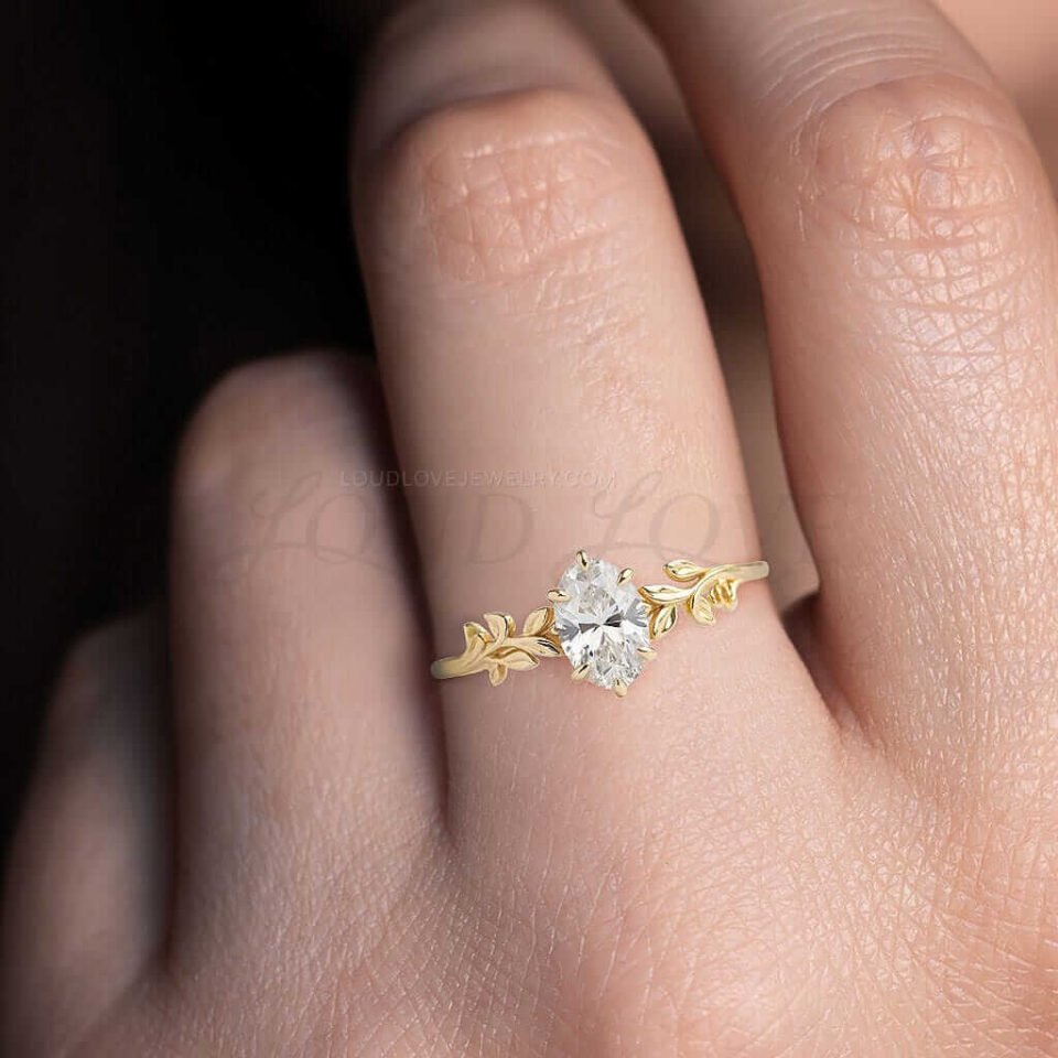 Leafy yellow gold band with an oval moissanite center stone.