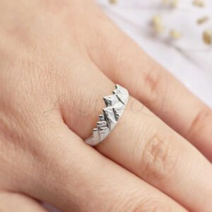 Unique mountain peak design silver ring resting on a hand.