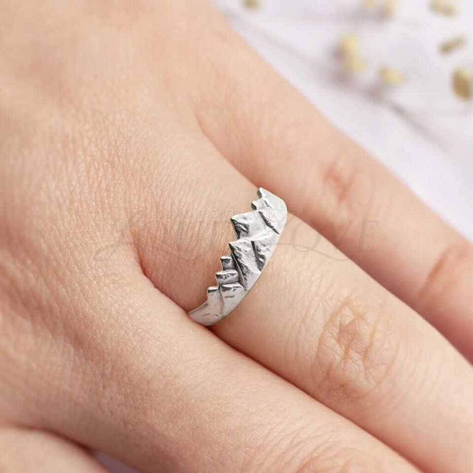 Unique mountain peak design silver ring resting on a hand.