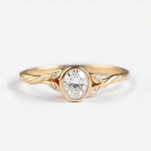 Oval moissanite bezel-set ring with twisted branch band and leaf-accented side stones.