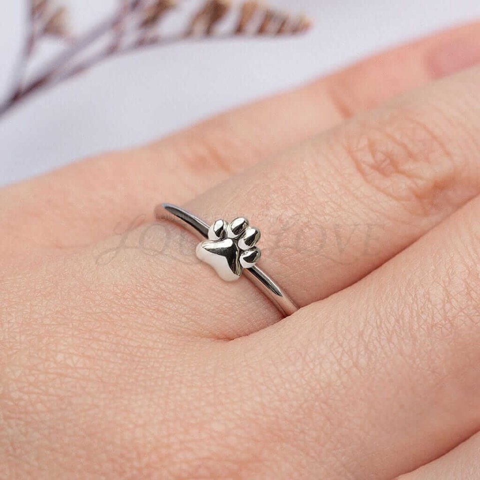 Slim paw print ring in silver or gold, styled for everyday wear with a minimalist look.