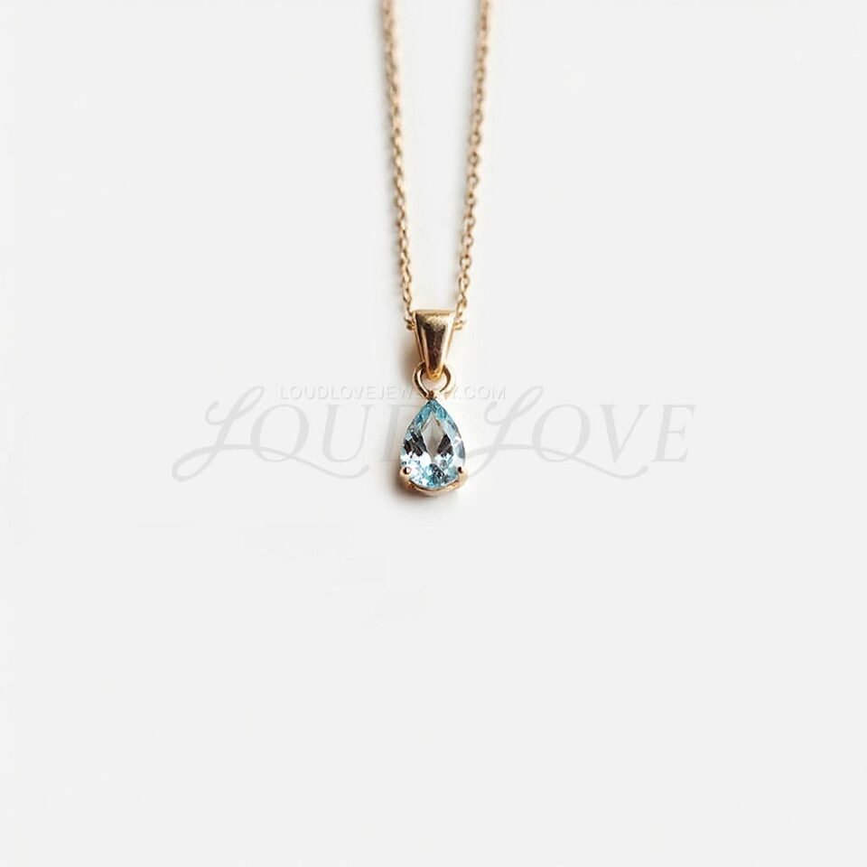 Pear-cut natural aquamarine pendant in a gold setting, shaped like a delicate water drop.