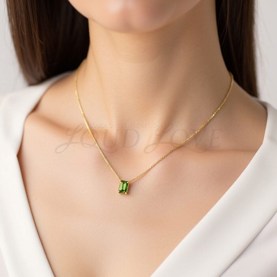 Striking green peridot in a sleek setting, worn as a modern August birthstone accessory.