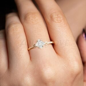 Angled princess cut moissanite ring with leaf-accented gold band worn as a unique engagement ring.