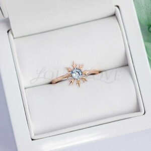 Hexagon aquamarine snowflake ring in rose gold shown in a soft-lined ring box.