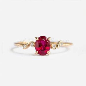 Oval lab ruby ring featuring gold accent and four side stones in a creative modern setting.