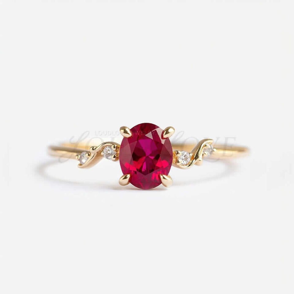 Oval lab ruby ring featuring gold accent and four side stones in a creative modern setting.