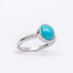 Polished silver ring with bezel-set turquoise cabochon, presented from the side view.
