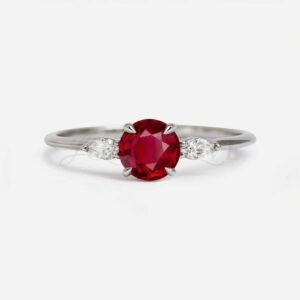 Sterling silver ring with round ruby center and marquise white stones in claw prongs.