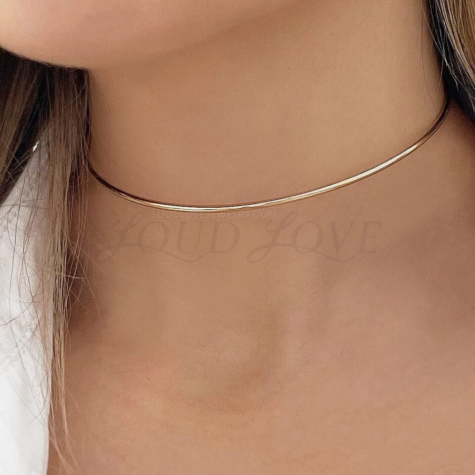 Sleek silver wire choker worn close to the neck, offering a refined and contemporary style.