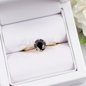 Solitaire ring with a round black diamond shown in a padded luxury box.