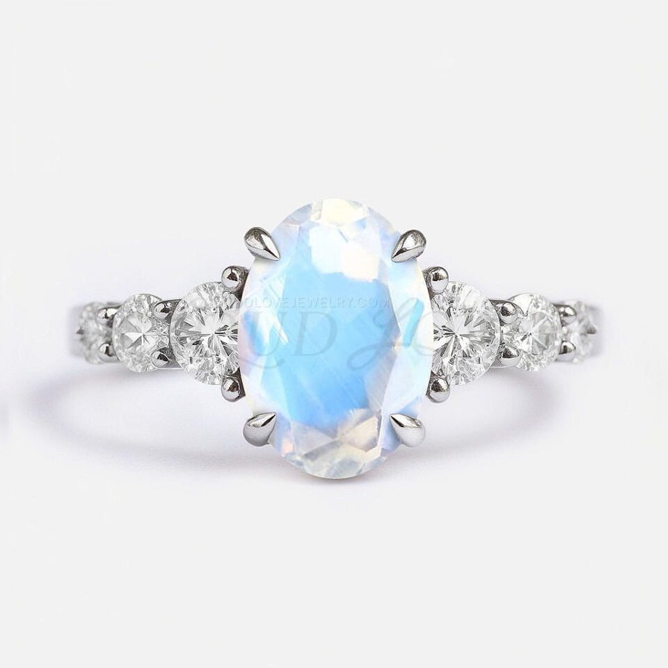 Oval moonstone ring in sterling silver with six side stones in a symmetrical setting.